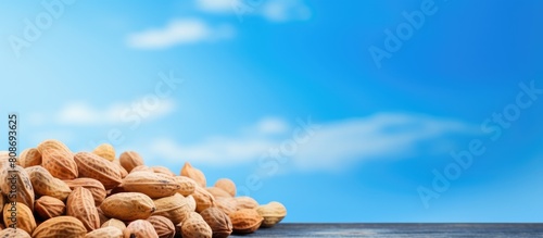 Close up of unpeeled peanut beans on a blue background with copy space image photo