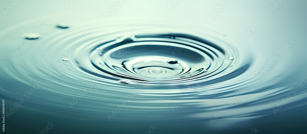 Water droplet creating ripples on the surface of a still body of water with ample empty space surrounding it for focus creating a captivating copy space image Water droplet creating ripples on the surface of a still body of water with ample empty space surrounding it for focus creating a captivating copy space image