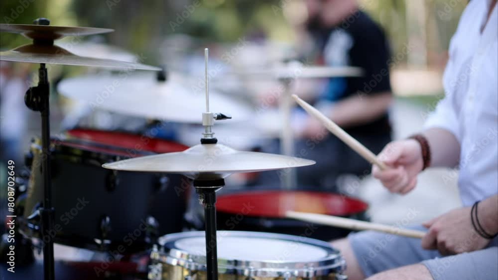 Close up of man playing red drums outside Close up of man playing red drums outside
