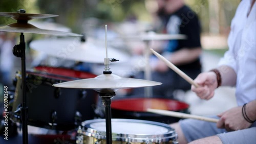 Close up of man playing red drums outside photo