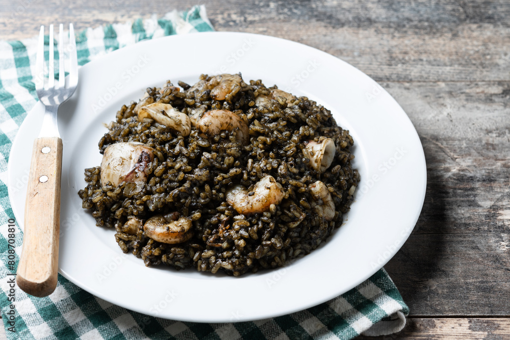 Black rice with seafood on wooden table Black rice with seafood on wooden table