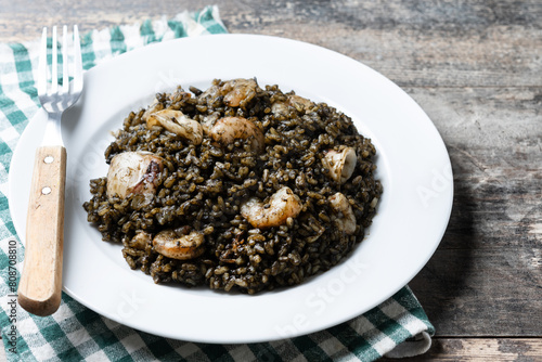 Black rice with seafood on wooden table photo