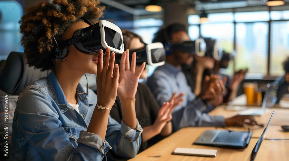 A group of diverse professionals wearing virtual reality headsets are sitting around a table and using their hands to interact with the virtual environment. A group of diverse professionals wearing virtual reality headsets are sitting around a table and using their hands to interact with the virtual environment.