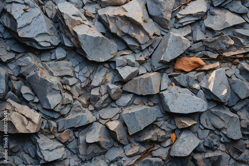 Autumn leaves add a touch of organic contrast to the solid grey stone wall, evoking a seasonal change
