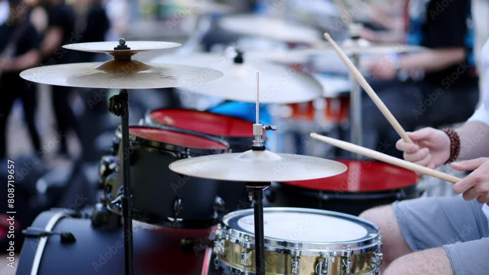 Close up of man playing red drums outside. Close up of man playing red drums outside.