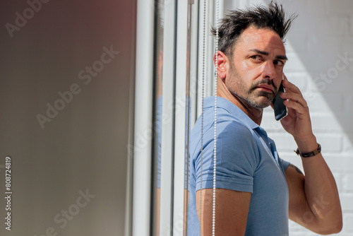 attractive man at home with mobile phone