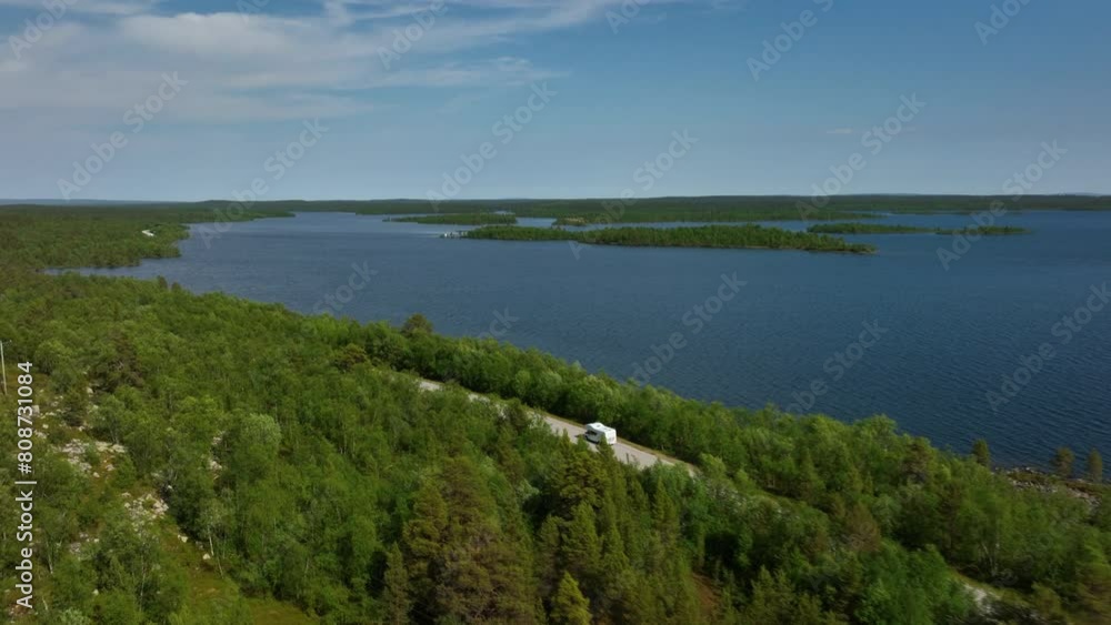 Aerial view following a camper driving in front of the Inarinjarvi lake in Finland Aerial view following a camper driving in front of the Inarinjarvi lake in Finland