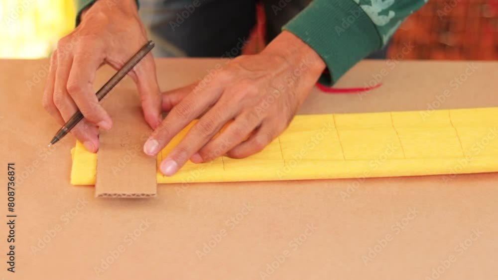 Artisan drawing lines on crepe paper and cutting it with scissors for decorations Artisan drawing lines on crepe paper and cutting it with scissors for decorations