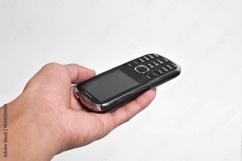 Hand holding Old Mobile Phone isolated on white background. Old cellular mobile phone Hand holding Old Mobile Phone isolated on white background. Old cellular mobile phone