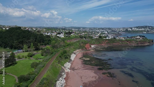 Paignton, Torbay, South Devon, England: DRONE VIEWS: The drone descends over Hollicombe beach showing the rugged coast and railway line to Paignton. Torbay is a popular UK holiday destination. photo