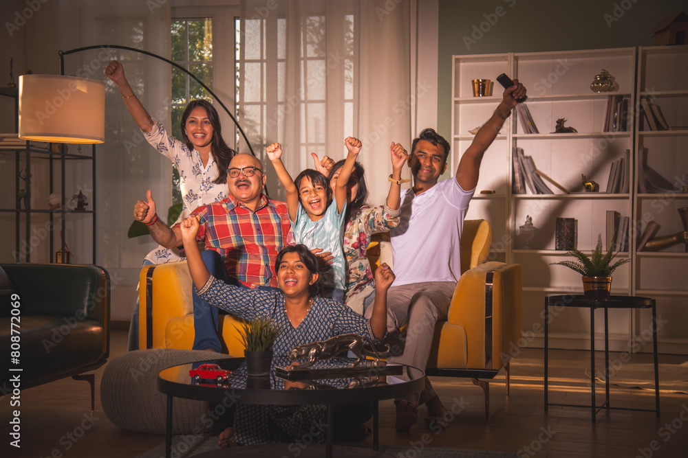 Fototapeta premium Indian big family watching television at home on sofa