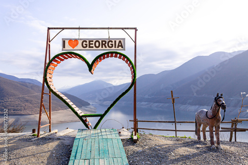 Mountain landscape of Georgia on bright summer sunny day. Mountain lake and hills covered with green grass against the background of the inscription I love Georgia photo
