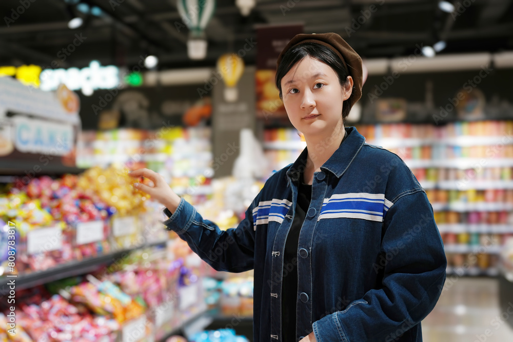 Young Woman Pondering Choices in Grocery Aisle