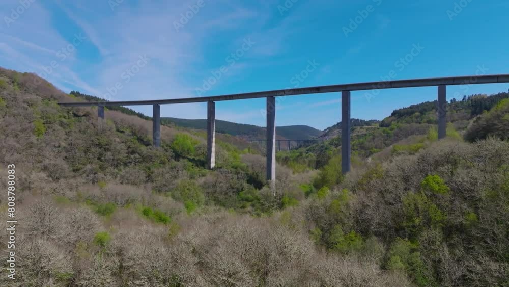 Drone shot of the elevated roadway crosses forest in the mountains near Becerrea city, Lugo, Spain Drone shot of the elevated roadway crosses forest in the mountains near Becerrea city, Lugo, Spain