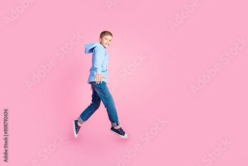 Full body profile photo of little energetic schoolkid jump empty space advert isolated on pink color background