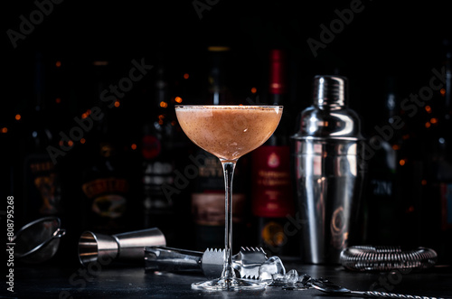 Coffee cocktail drink with cocoa liquor, irish cream and ice in glass, dark bar counter background