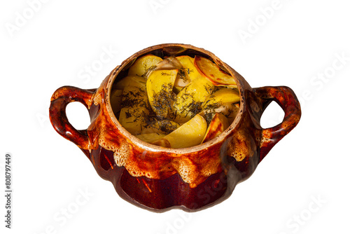 Potatoes baked in a cauldron.On a white isolated background. The chef prepares fried potatoes in a wood-burning oven in nature. Decorated with greenery. Close-up. food on a round plate.