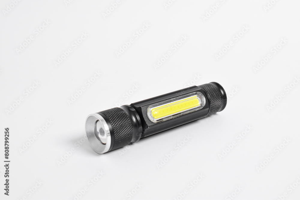 Modern metal LED flashlight in black color isolated on white background. Portable flashlight, LED camping flashlight Modern metal LED flashlight in black color isolated on white background. Portable flashlight, LED camping flashlight