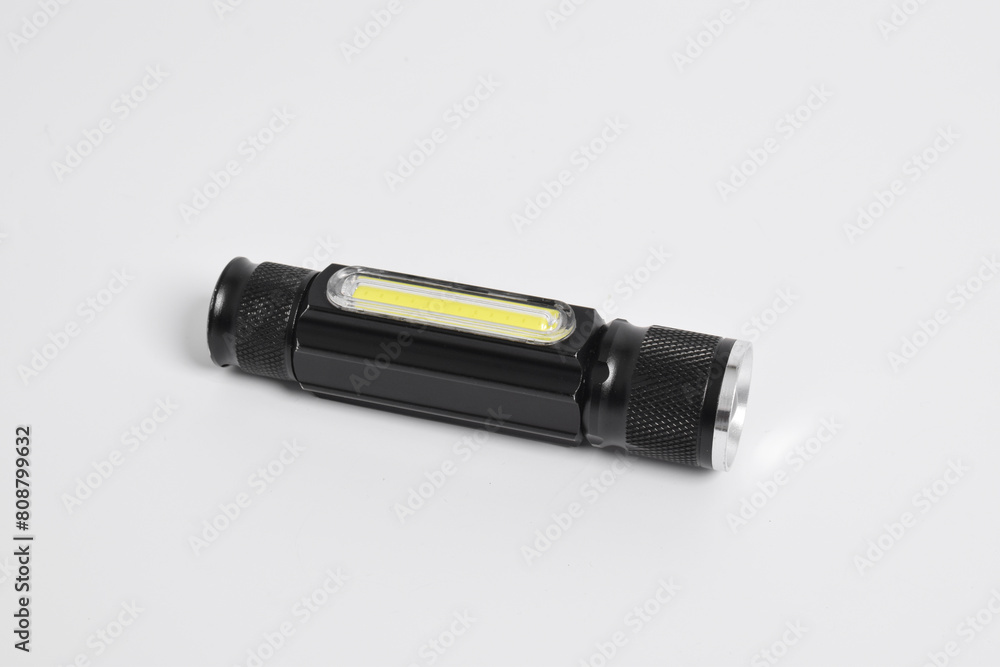 Modern metal LED flashlight in black color isolated on white background. Portable flashlight, LED camping flashlight Modern metal LED flashlight in black color isolated on white background. Portable flashlight, LED camping flashlight