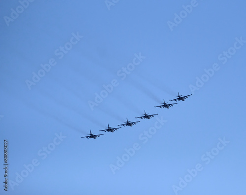 Fighter jet formation of six Russian military tactical frontline bombers SU-25 Frogfoot fast flying in cloudless blue sky photo