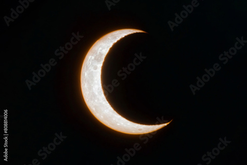 A crescent moon is in the sky with on black background