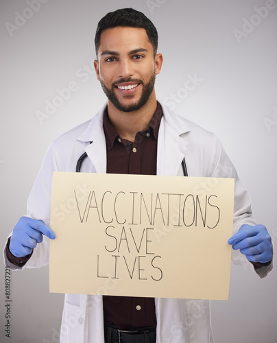 Health, vaccine poster and doctor in portrait for advice, covid 19, healthcare or safety from corona virus. Medical professional, pro vaccination or male person in studio for wellness, sign or expert photo