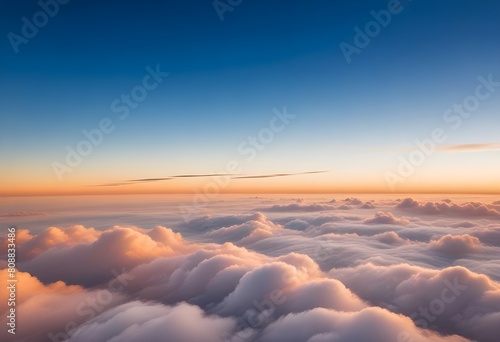 Aerial view of clouds at sunset, with a clear blue sky above the cloud layer