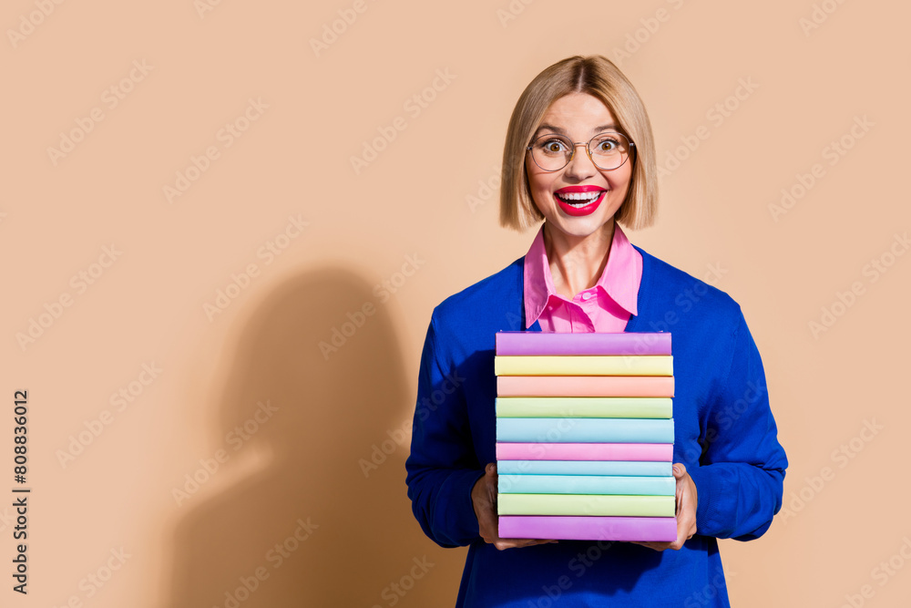 Photo of intelligent astonished lady hands hold pile stack book empty space ad isolated on beige color background Photo of intelligent astonished lady hands hold pile stack book empty space ad isolated on beige color background