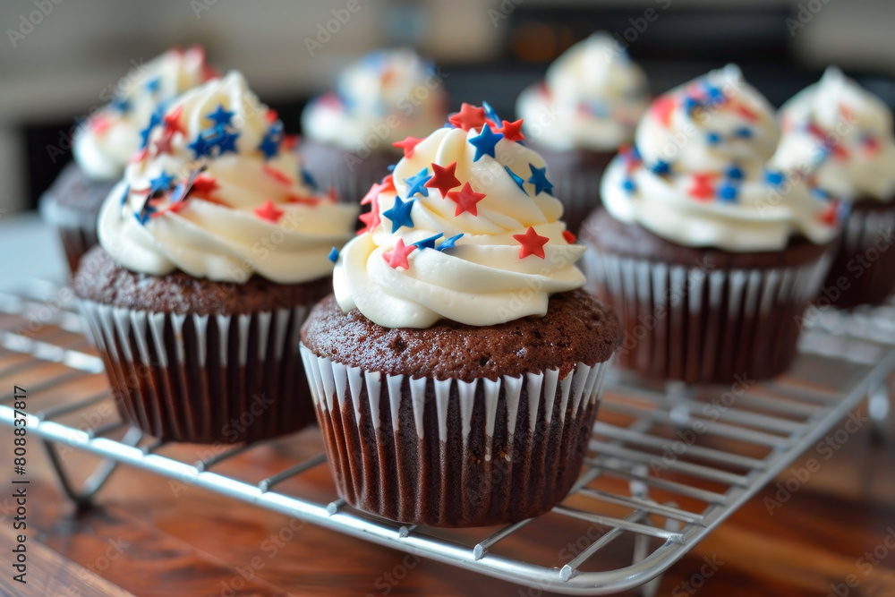 4th of july chocolate cupcakes with cream cheese and blue and red sprinkles on wooden table