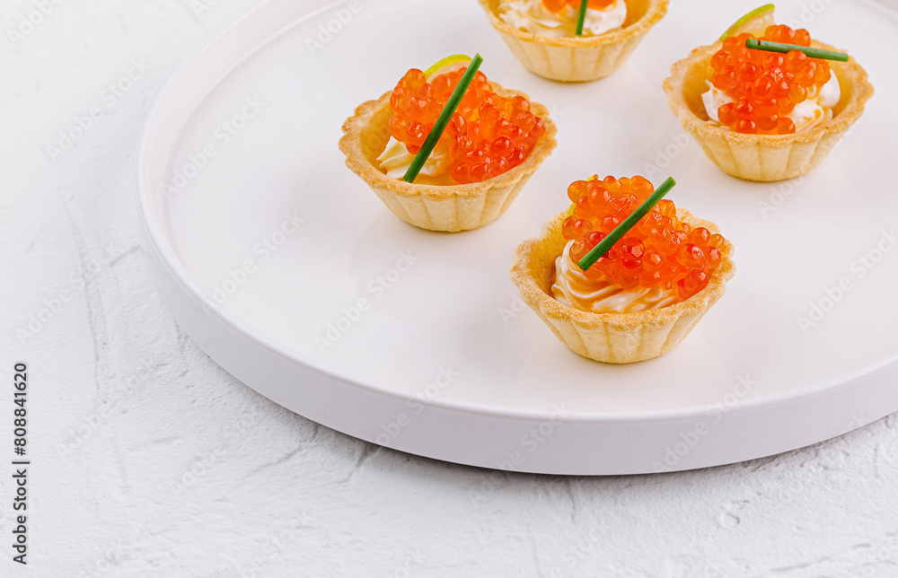 Elegant tartlets with salmon caviar on white plate Elegant tartlets with salmon caviar on white plate