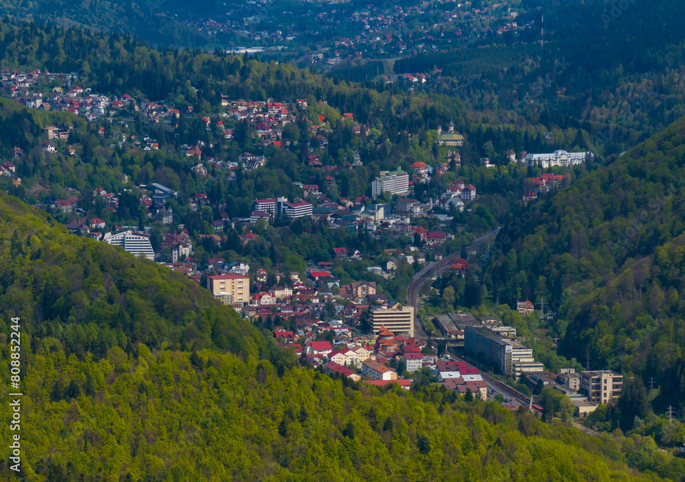 Travel to Romania Carpathian mountain side. Aerial drone photo with Sinaia mountain resort located in Prahova Valley (Valea Prahovei in Romania) at the bottom of Bucegi mountains. 