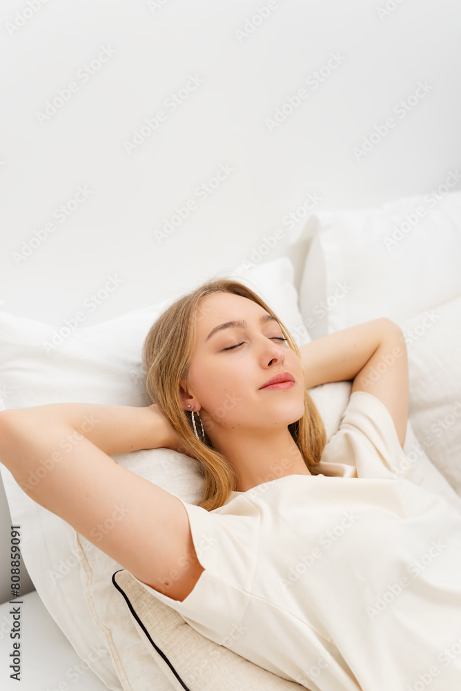Smiling young woman with closed eyes resting on the bed in her bedroom. Smiling young woman with closed eyes resting on the bed in her bedroom.