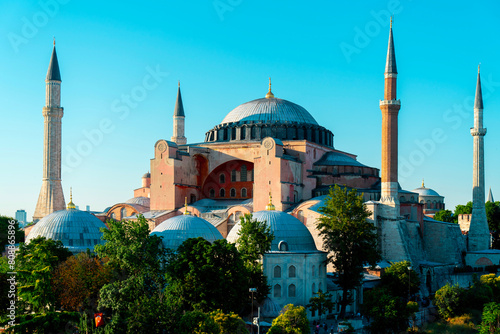 Hagia Sophia Mosque in Istanbul is a place of worship for Muslims. The photo of the building, which is surrounded by green trees, was taken on a sunny day.