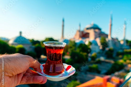 A man drinks Turkish tea opposite the Hagia Sophia Mosque. The man drinks his tea while admiring the view. Istanbul Turkey. photo