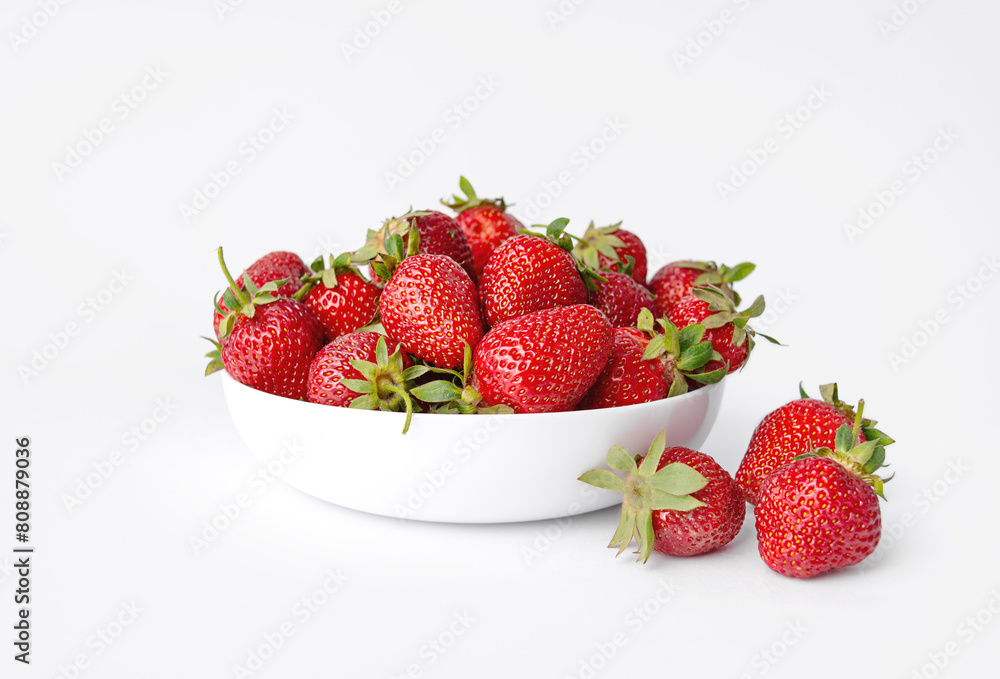 Strawberries in a white ceramic plate on a white background. Strawberries in a white ceramic plate on a white background.