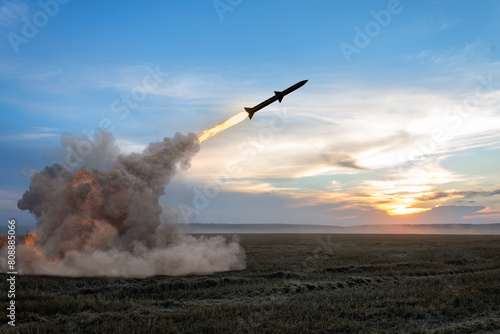Launching a rocket from a rocket launcher in the fields. Concept: war in Ukraine, missile attack, Russian nuclear threat.
