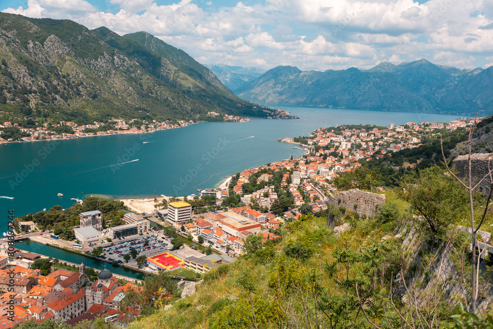 Panoramic view of Boko Kotor Bay and old town. Landscape with beautiful mountains, sea and clouds. Summer vacation at resort of Montenegro