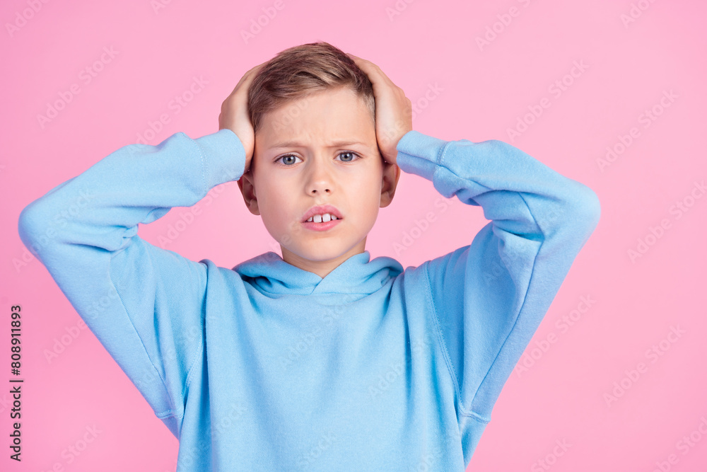 Photo of impressed disappointed boy arms touch head bad news empty space isolated on pink color background Photo of impressed disappointed boy arms touch head bad news empty space isolated on pink color background