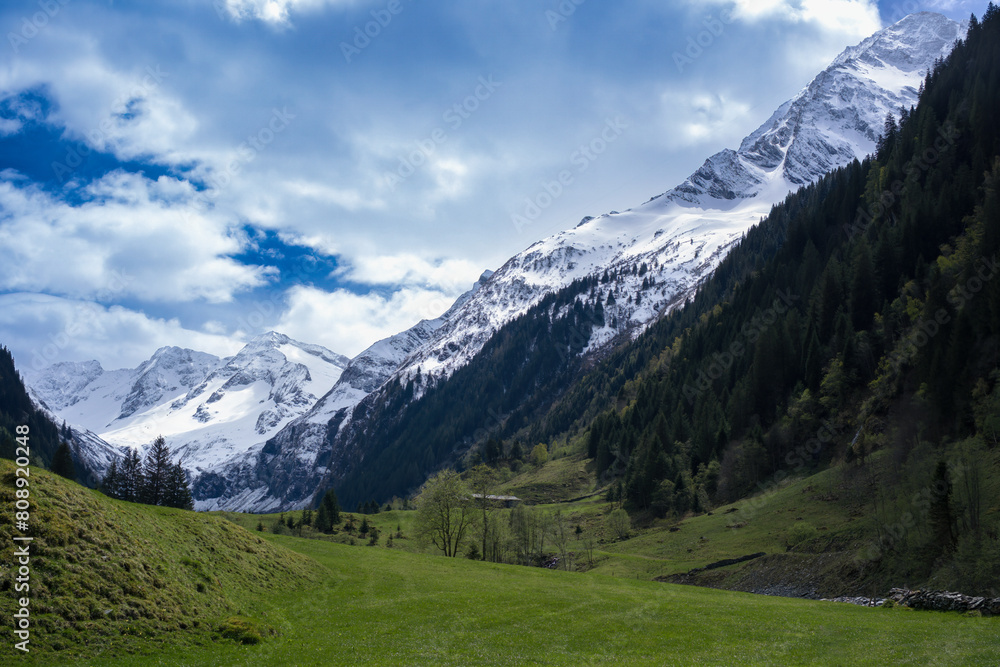 hiking holiday in the austrian mountains, in the hohen tauern national park, with a beautiful view of the snow capped alps at a sunny and cloudy spring day hiking holiday in the austrian mountains, in the hohen tauern national park, with a beautiful view of the snow capped alps at a sunny and cloudy spring day