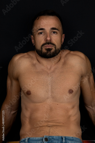 Strong man without shirt on black background