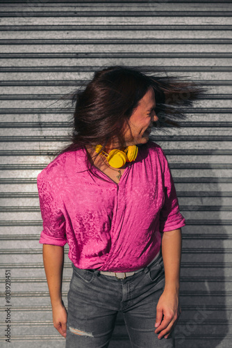 Funny and inspirational portrait of trans woman shaking head against grey wall. LGBT concept.