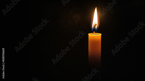 Single Burning Candle with Bright Flame on Dark Black Background Symbolizing Hope and Remembrance