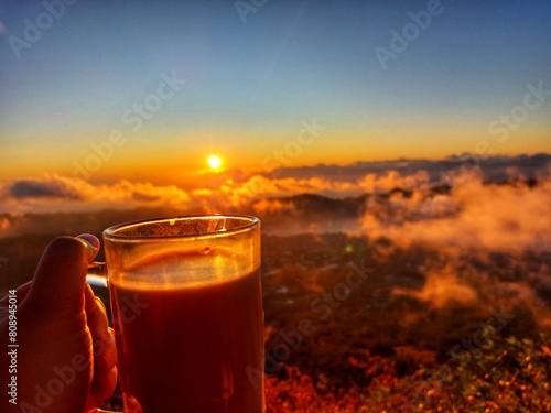 the view of the sunrise on the mountain accompanied by a cup of chocolate milk