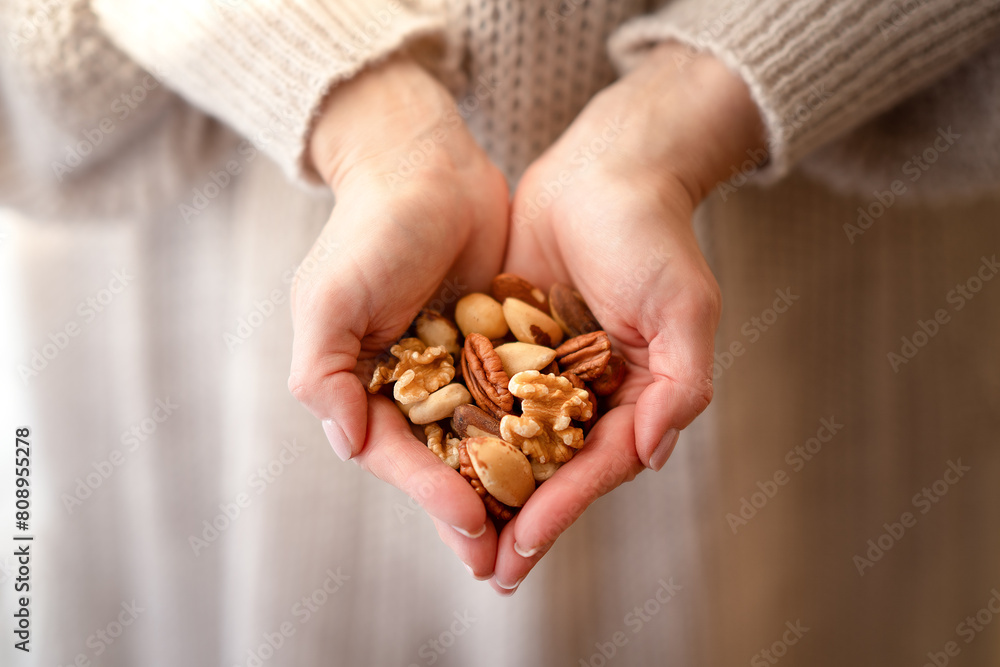 Ταπετσαρία A mixture of different nuts in the hands of a woman