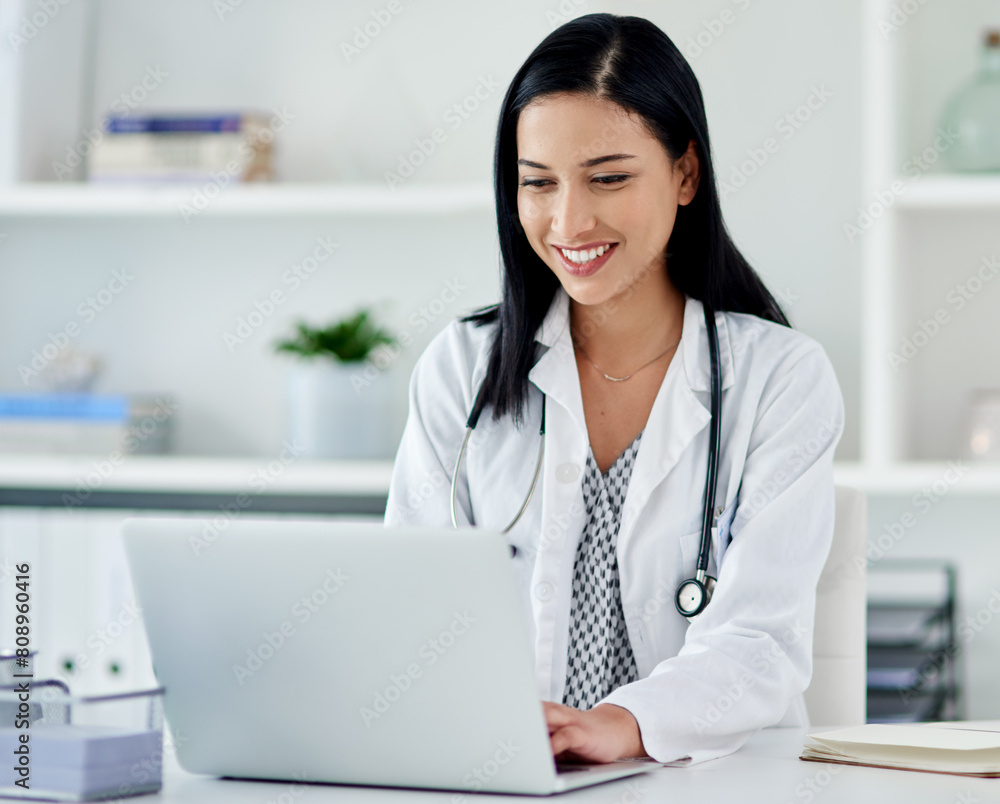 Doctor, smile and laptop by desk in office for telehealth, communication and medical research. Healthcare, professional and woman with technology at hospital for digital report, planning and feedback Doctor, smile and laptop by desk in office for telehealth, communication and medical research. Healthcare, professional and woman with technology at hospital for digital report, planning and feedback