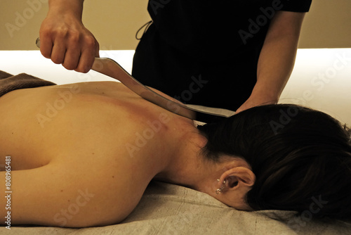 Physiotherapist applying massage therapy with stainless steel tool