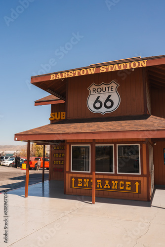 Barstow Station building on Route 66 in the USA, with wooden facade and SUB sign hinting at food services. Americana aesthetic, sunny day, operational location.