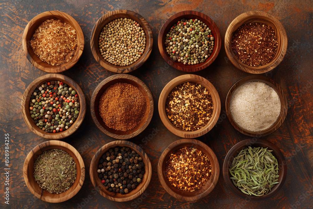 assortment of differrent spices in wooden bowls over table background