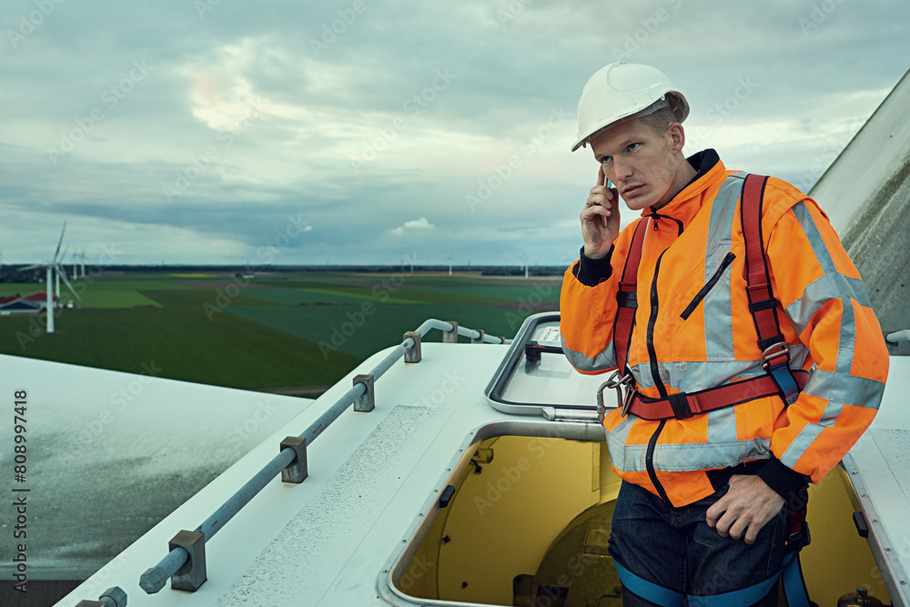Wind turbine, phone call and man in electricity maintenance of industrial grid on production farm. Renewable energy, quality assurance and technician with smartphone at electrical windmill in field. Wind turbine, phone call and man in electricity maintenance of industrial grid on production farm. Renewable energy, quality assurance and technician with smartphone at electrical windmill in field.