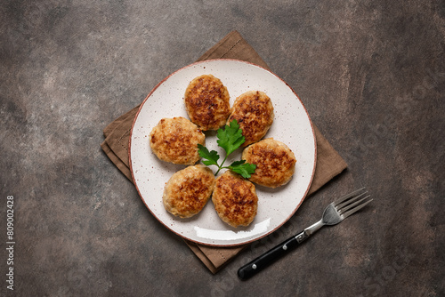 Fried meat cutlets in a plate on a dark background. Top view, Flat lay